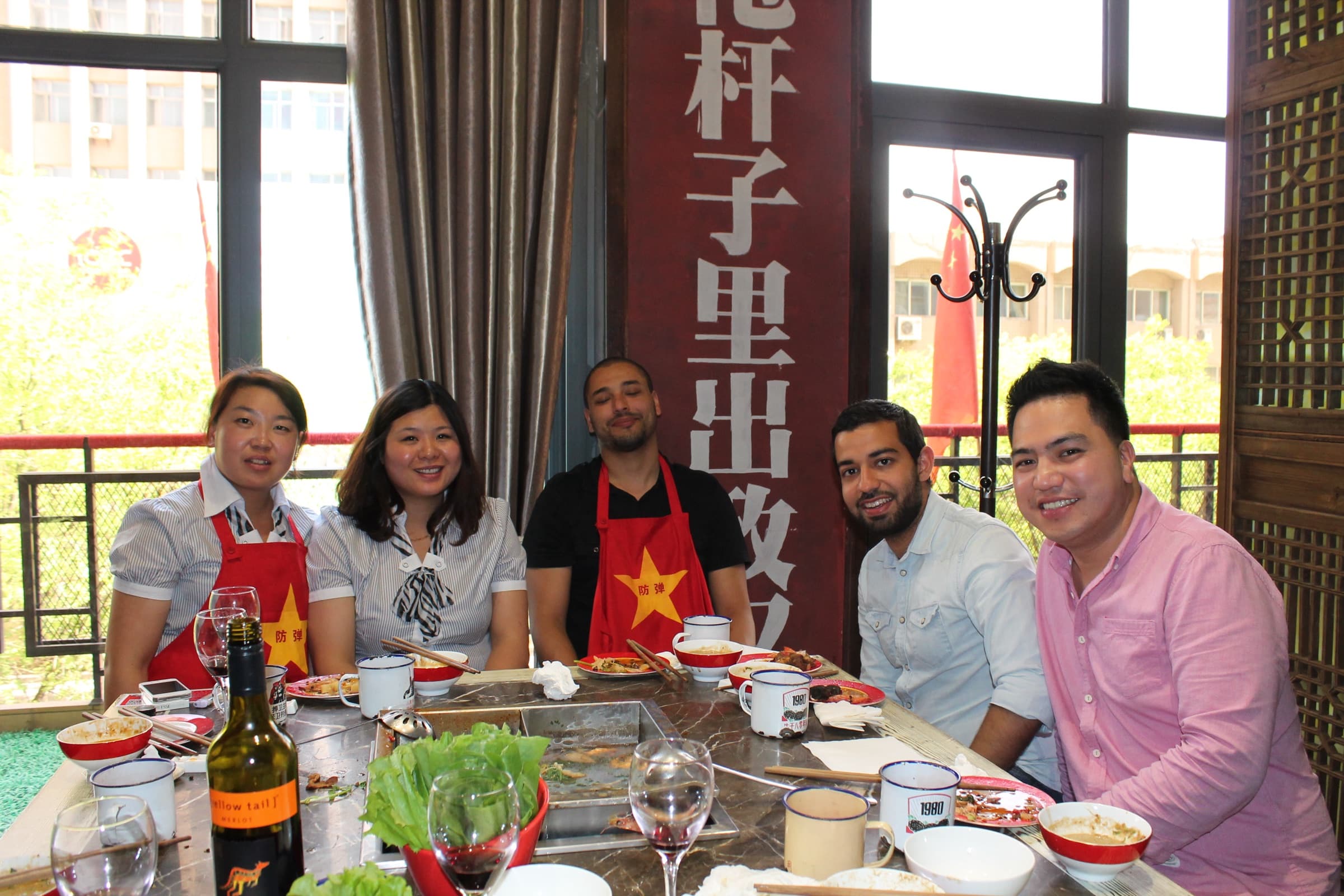 Grande tablée dans un salon de restaurant : une dizaine de convives, chinois et étrangers, autour d’un plateau tournant couvert de plats.